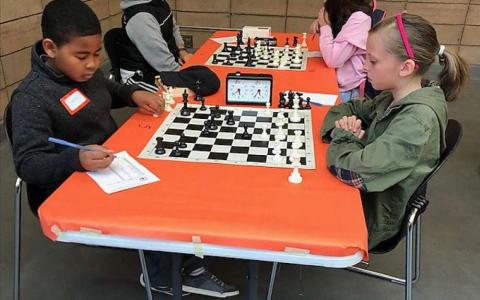 Photograph of two children playing chess